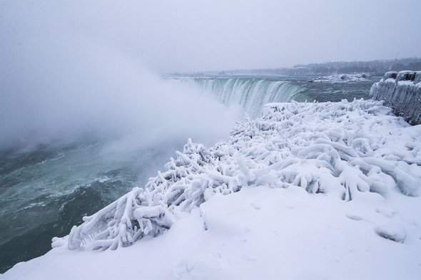 В США из-за зимней аномалии Ниагарский водопад покрылся льдом (фото)